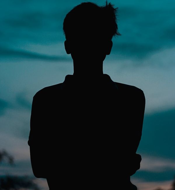 Silhouette of a person meditating against a sunrise background.